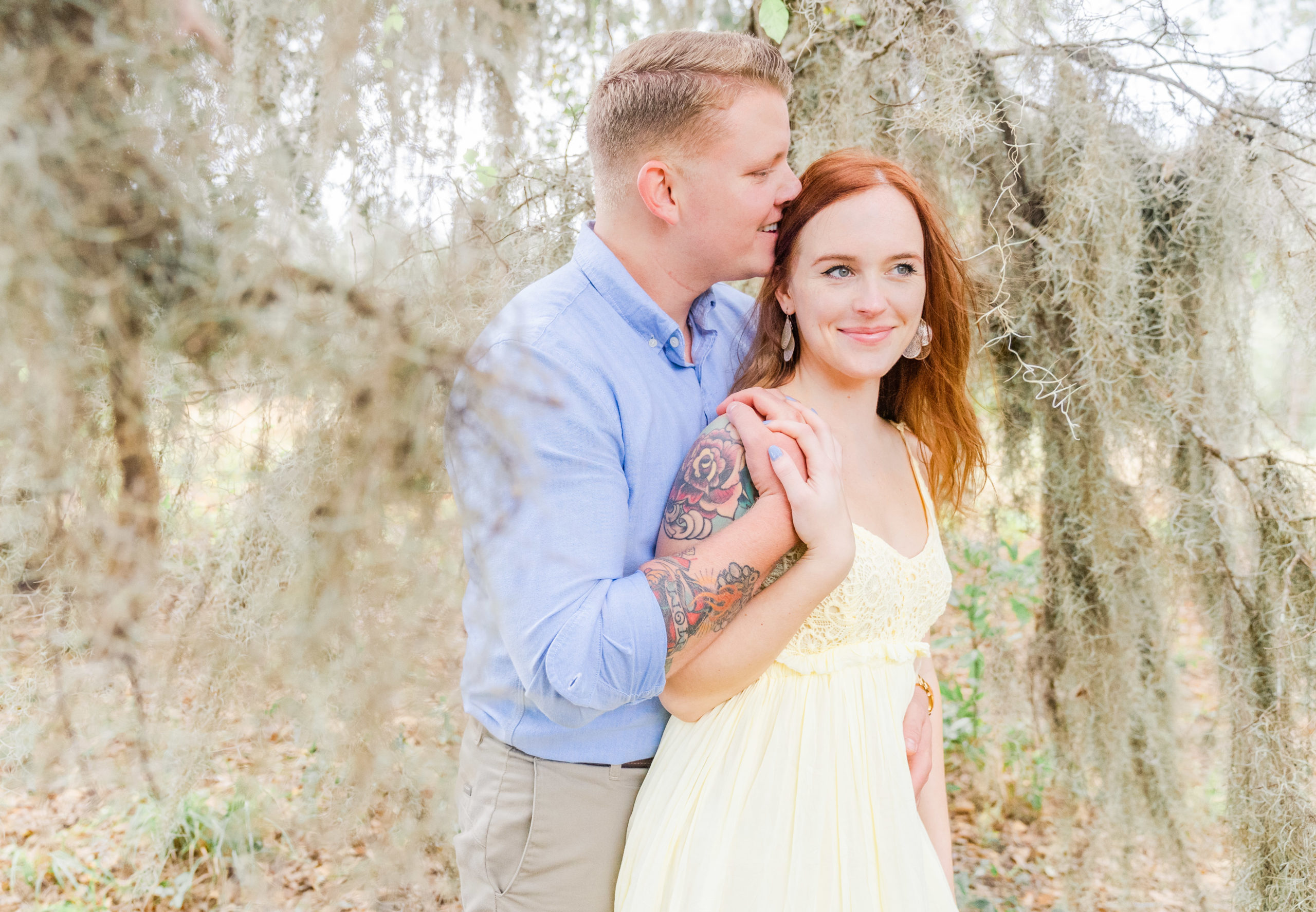 engagement picture shows off tattoos in spanish moss at the bluff venue in kingsland georgia