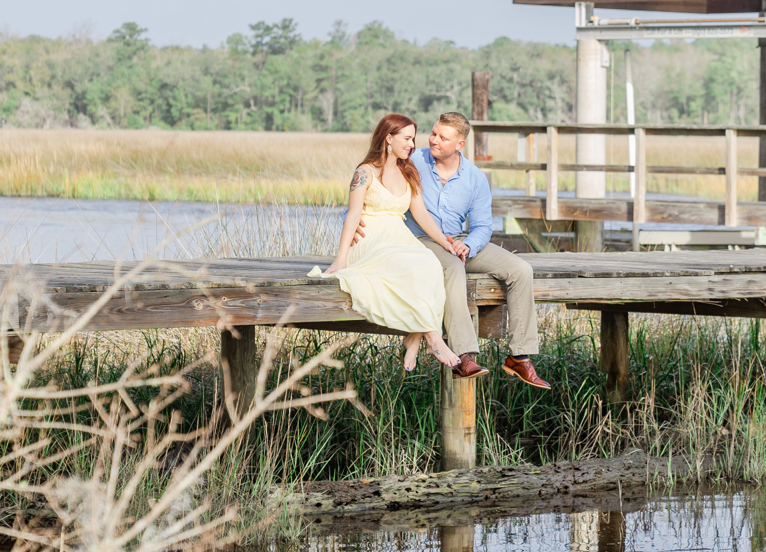 engagement picture couple sitting on boat dock in kingsland georgia at the bluff venue