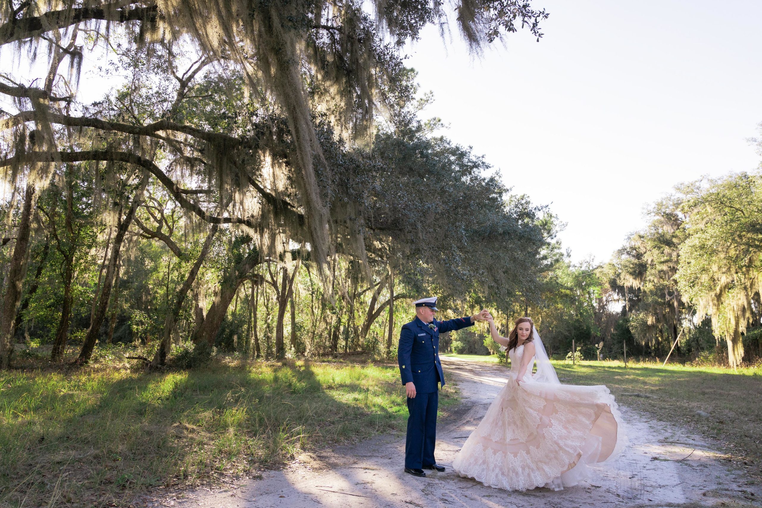 wedding portrait of couple dancing on a dirt road under spanish moss oak trees in kingsland georgia at the bluff venue