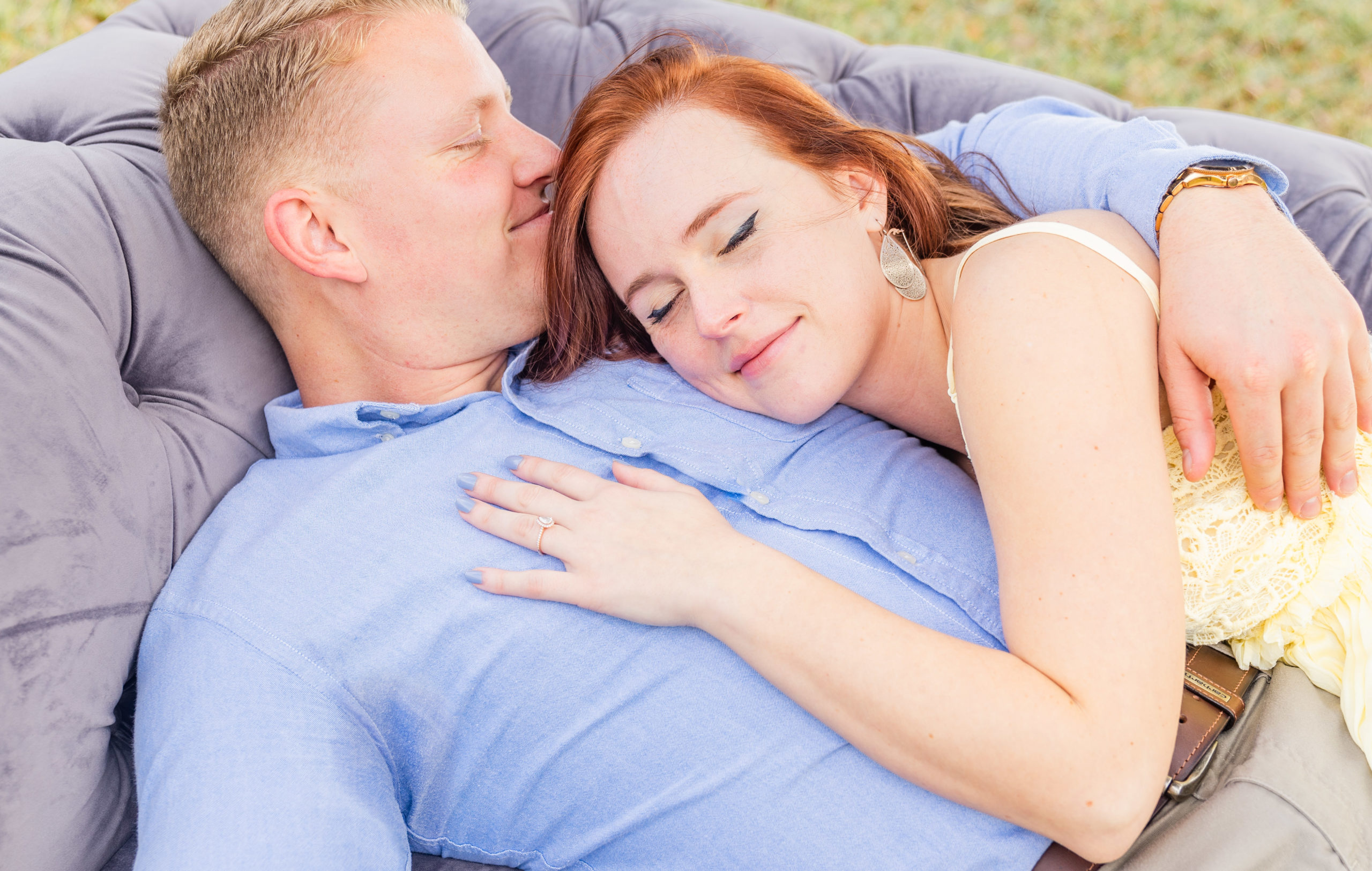 couple laying on the grey couch engagement photo in kingsland georgia at the bluff venue