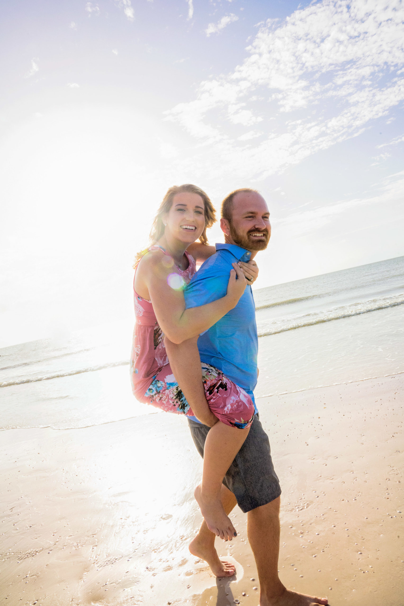 honeymoon island beach in tampa florida engagement session of bride sitting on grooms back