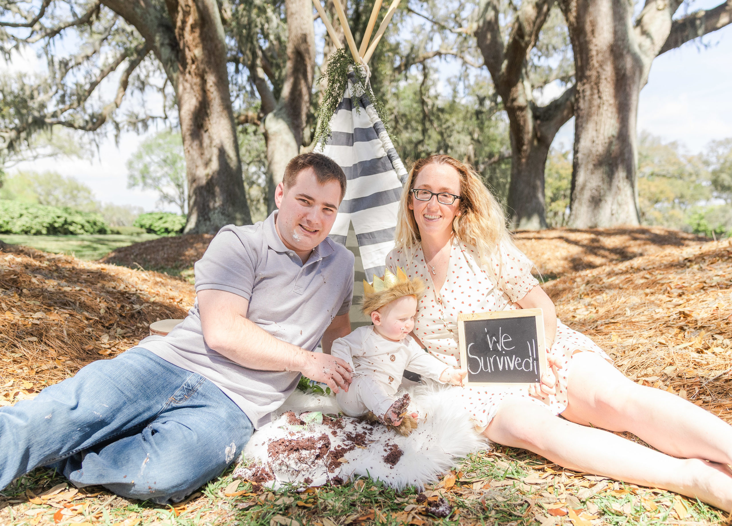 family session cake smash with tent and chaulk sign at avenue of the oaks
