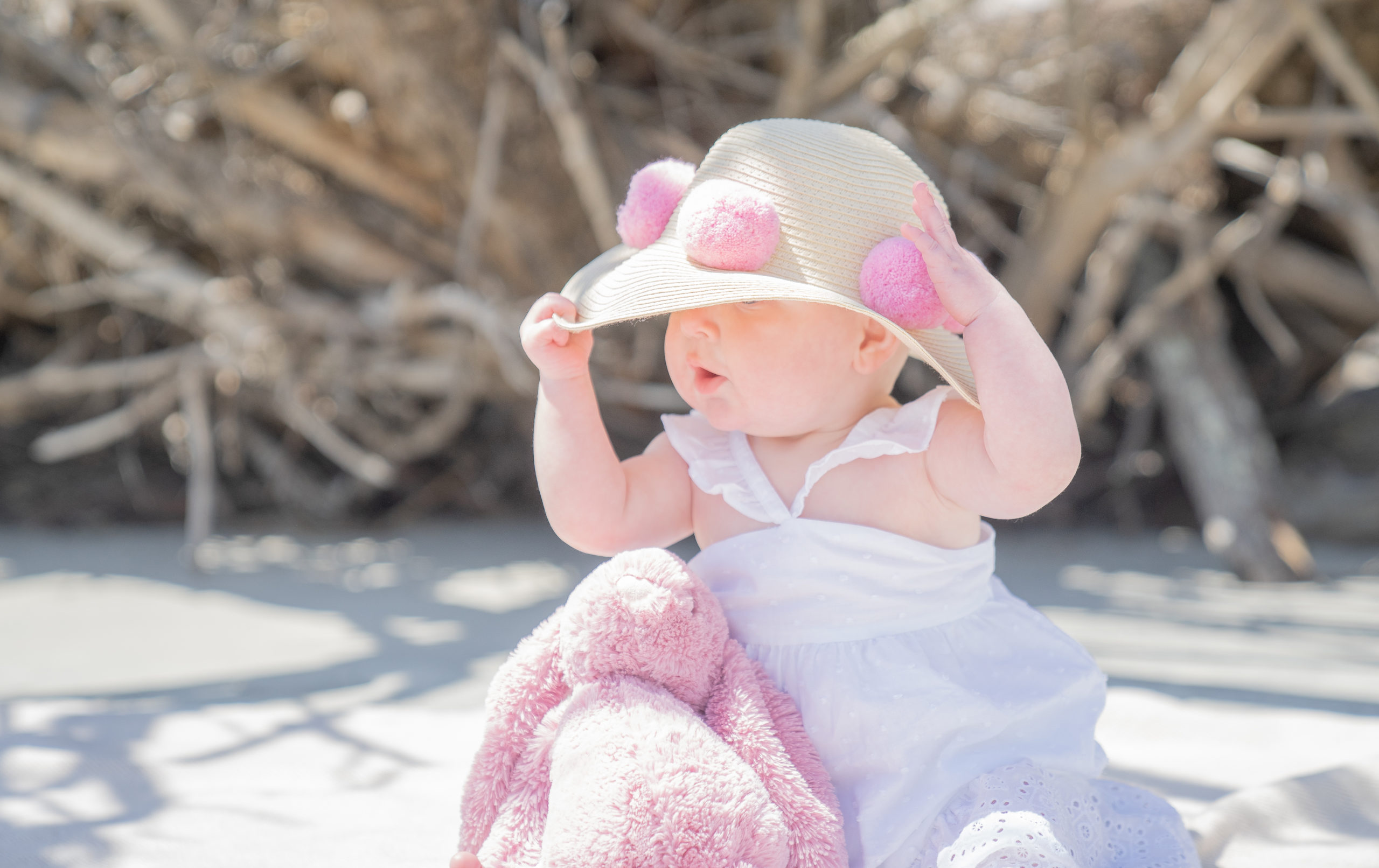baby girl wearing hat at driftwood beach jekyll island