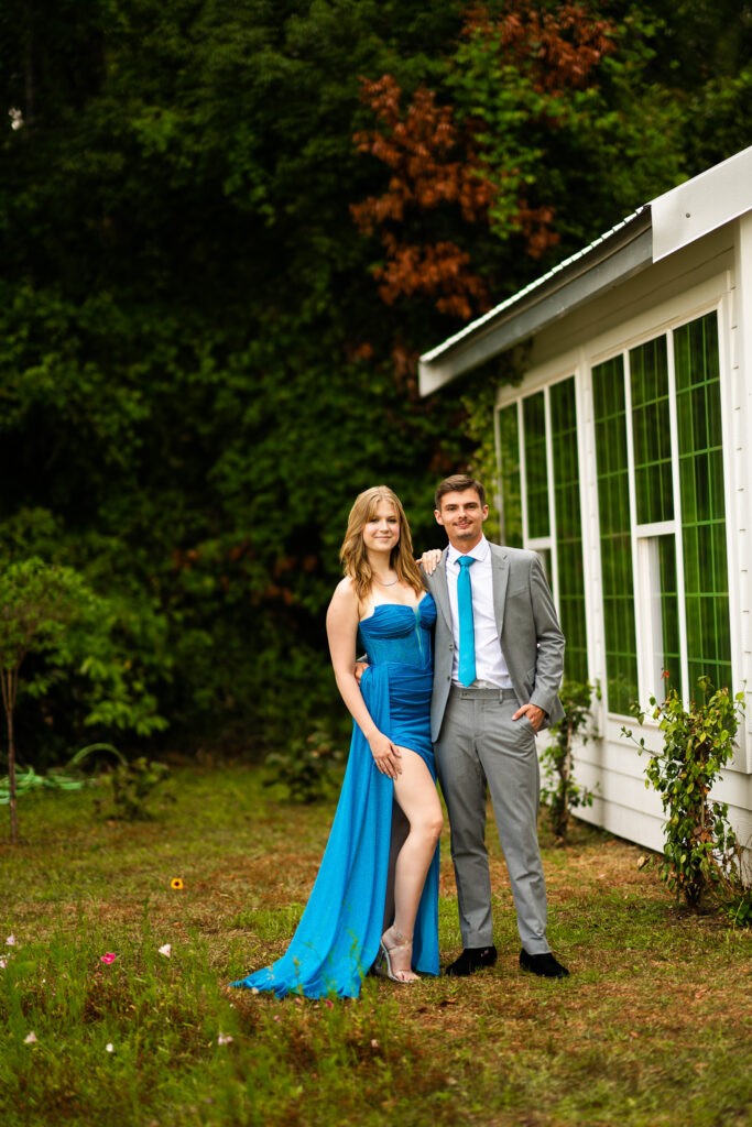 Prom pictures in front on greenery and a white cottage