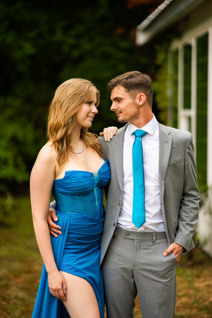 Prom pictures in front on greenery and a white cottage
