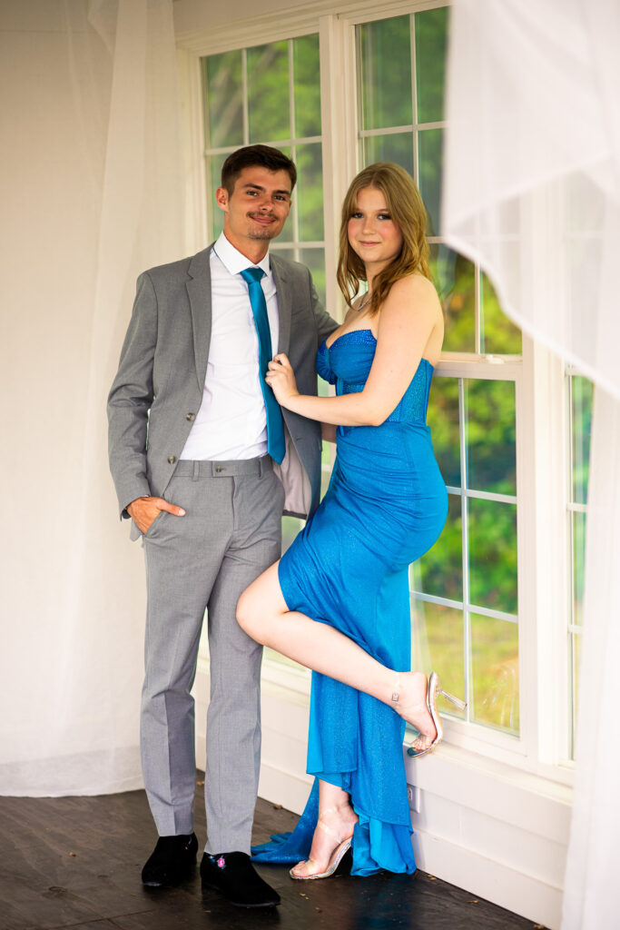 Prom pictures in front on greenery and a white cottage